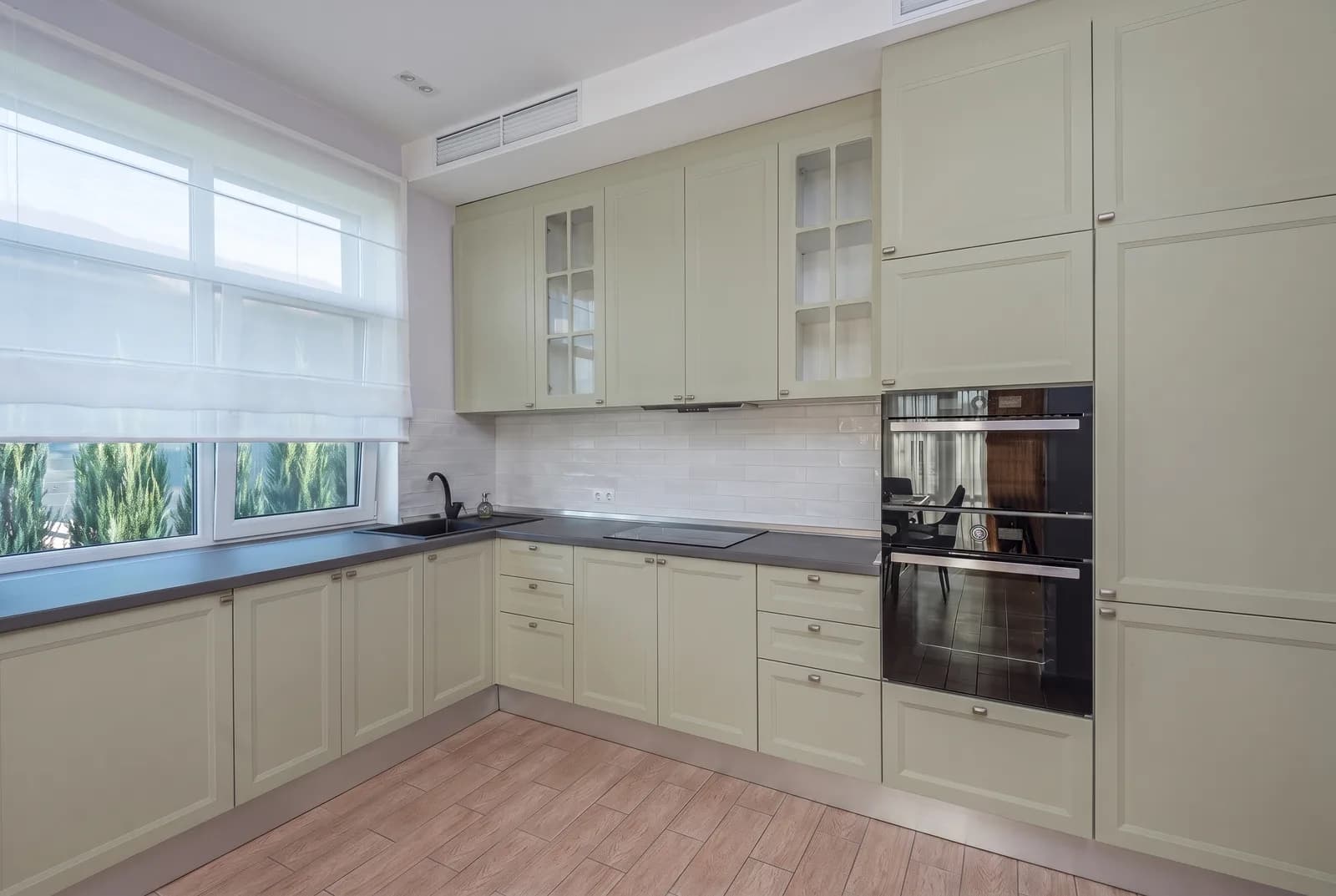 Kitchen cabinets rendered in Sherwin-Williams Clary Sage SW 6178, tile, counters and floor unchanged