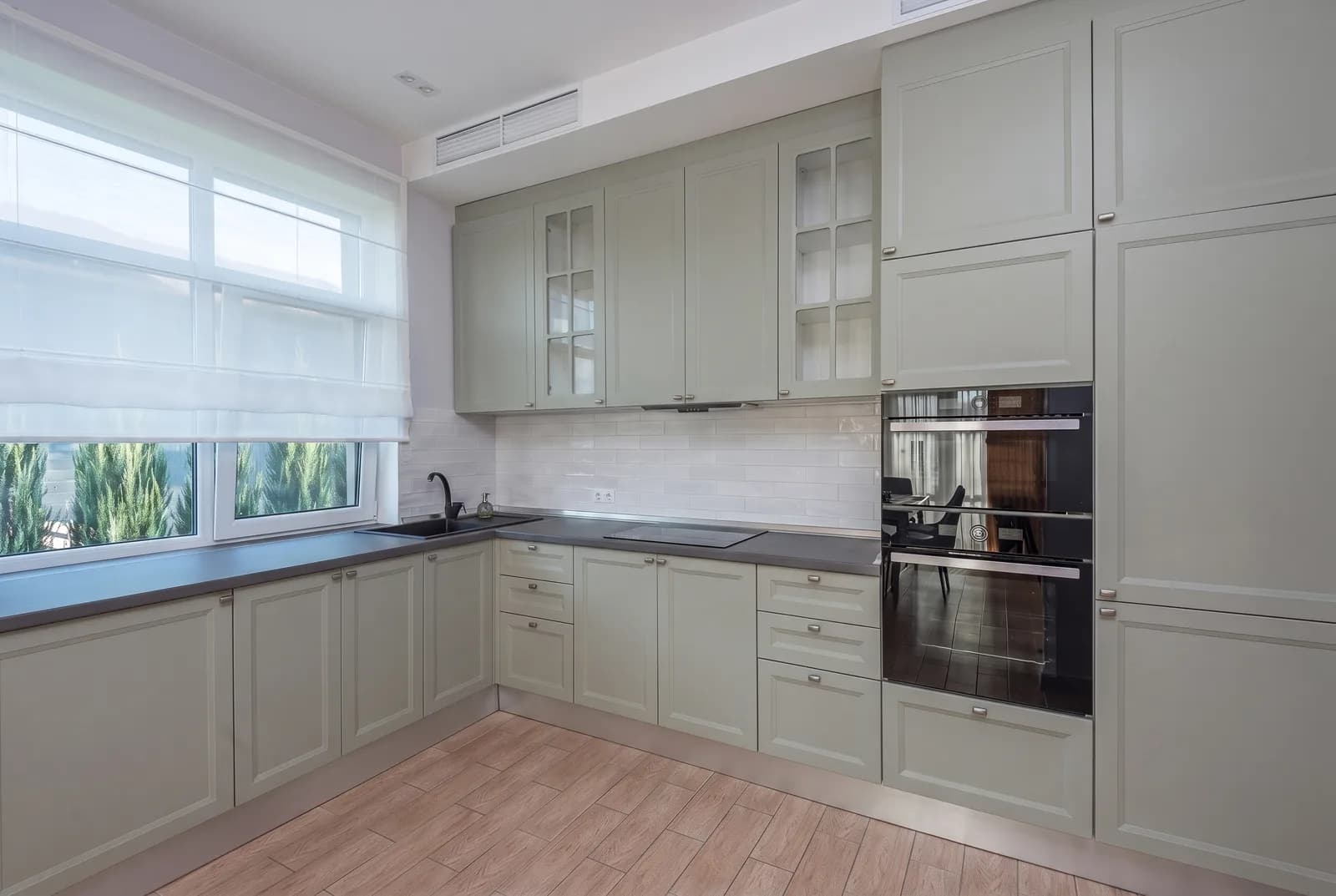 Kitchen cabinets rendered in Sherwin-Williams Evergreen Fog SW 9130, tile, counters and floor unchanged